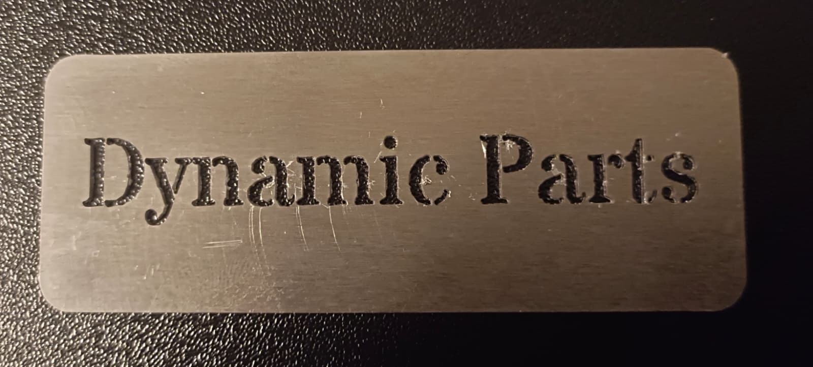 Lasergeschnittenes Metallschild mit ausgeschnittenem Schriftzug „Dynamic Parts“