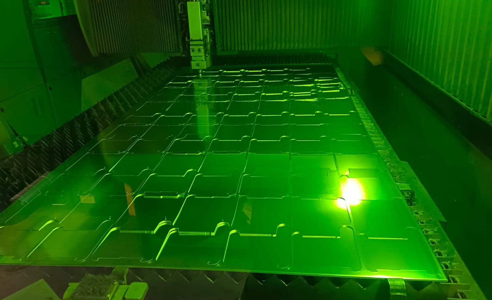 Laserschneidanlage beim Schneiden einer Blechtafel voller gleicher Teile